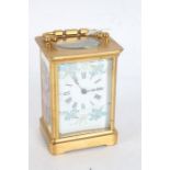 French brass cased and enamel carriage clock, the white enamel dial with blue and gilt floral sprays