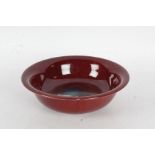 Chinese sang de boeuf bowl, the flared rim above a tapering bowl, raised on a pierced hardwood