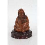 Chinese carved bamboo depiction of a seated monk, , on a hardwood stand, 14.5cm high