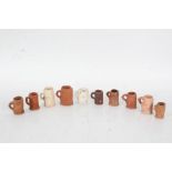 Collection of miniature tankards all decorated with various scenes of people buildings and
