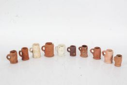 Collection of miniature tankards all decorated with various scenes of people buildings and