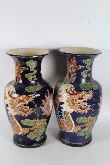 Pair of large Chinese vases, each with dragons on a blue ground, 2cm tall (2)