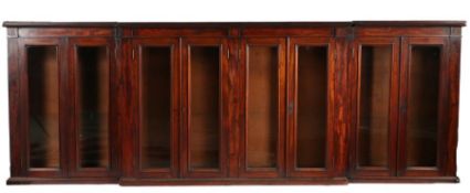 Victorian mahogany breakfront bookcase, the pediment above eight glazed doors opening to reveal