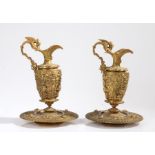 Pair of gilt metal ewers and dishes, in the renaissance taste, with an angle surrounding the