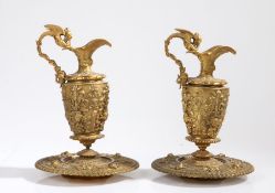 Pair of gilt metal ewers and dishes, in the renaissance taste, with an angle surrounding the