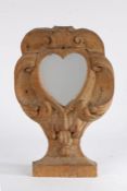 An 18th Century oak pier mirror, the later central heart mirror with C scrolls and arching frame,