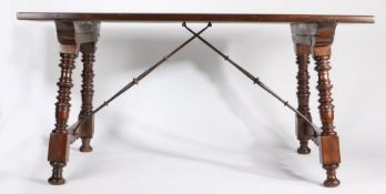 A Spanish walnut table, the rectangular top above ring turned and slightly angled legs fitted with