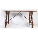 A Spanish walnut table, the rectangular top above ring turned and slightly angled legs fitted with