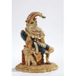 Victorian cast iron Mr Punch doorstop, modelled seated on a stack of books with dog wearing a plumed