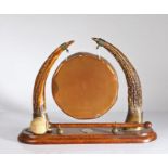 Oak, copper and antler dinner gong, the circular copper gong raised on two antler supports, on an