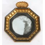 Regency convex wall mirror, the gilt and ebonised orb decorated octagonal frame with shell form