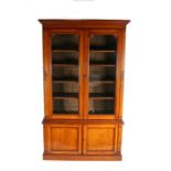 Late Victorian oak bookcase, with two glazed doors opening to reveal five shelves on top of a base