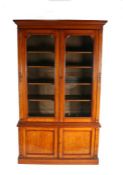 Late Victorian oak bookcase, with two glazed doors opening to reveal five shelves on top of a base