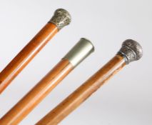 Three Victorian malacca walking sticks to include example with silver scroll embossed cap, similar