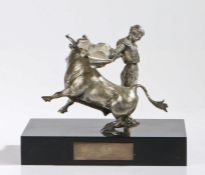 Silvered metal sculpture depicting a bull and matador, on a black plinth base with vacant
