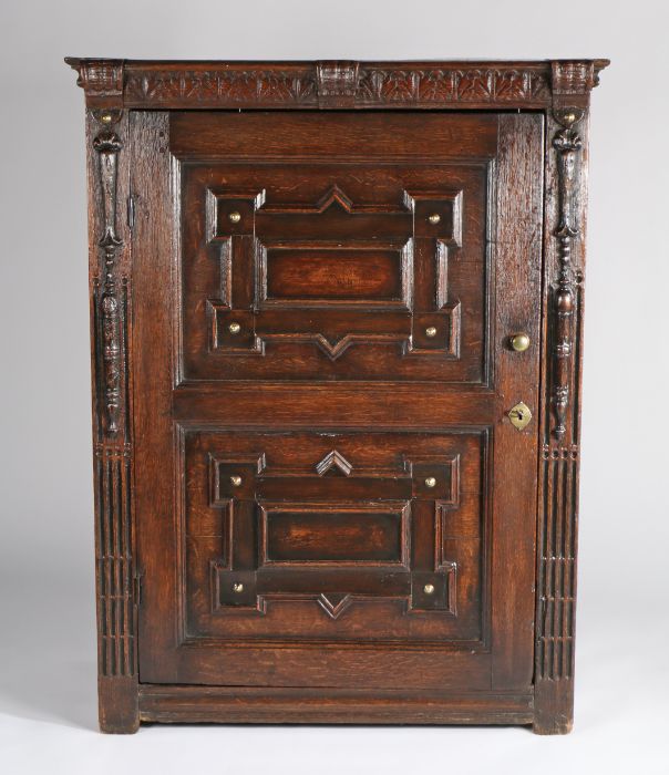 A 17th Century oak Flemish cabinet, the rectangular top above a leaf a carved frieze and twin