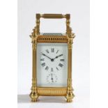 Late 19th Century French brass carriage clock, the reeded pilastered case with swing handle, the