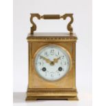 Late 19th Century French brass carriage clock the case with reeded swing handle, the white enamel