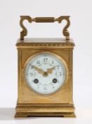 Late 19th Century French brass carriage clock the case with reeded swing handle, the white enamel