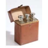 Three mid 20th Century spirit flasks, the chrome screw fitting caps opening to reveal glass