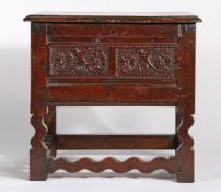 17th Century and later oak box stool, the hinged rectangular top above a flower head carved front