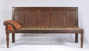 An 18th Century oak settle. the five panel back above a robe seat and arched stuff over rest to