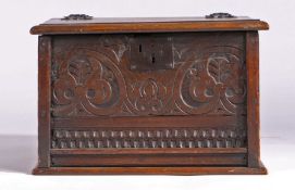 An oak box, made from 17th Century and later panels, the hinged top above a carved front panel, 50cm