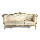 Continental gilt wood settee, with an undulating back carved with flowers above a button back and