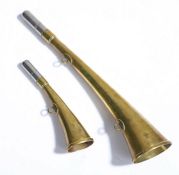 Two brass hunting horns, the white metal mouthpieces above flared tapering bodies, engraved "