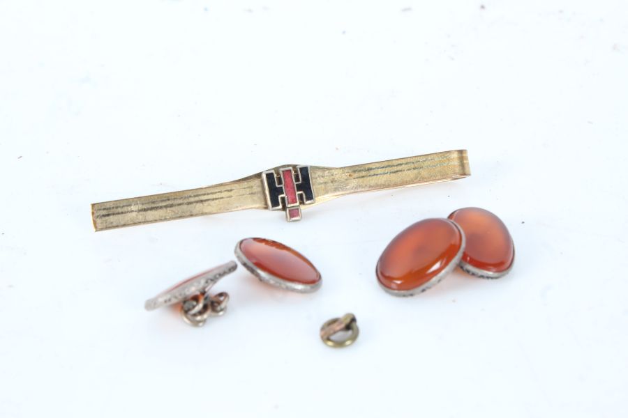 A rolled gold tie pin, and a pair of oval amber cuff-links
