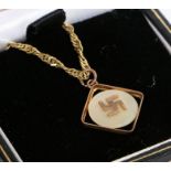 A 9 carat yellow gold pendant with a Swastika set on mother of pearl suspended from a 9 carat yellow