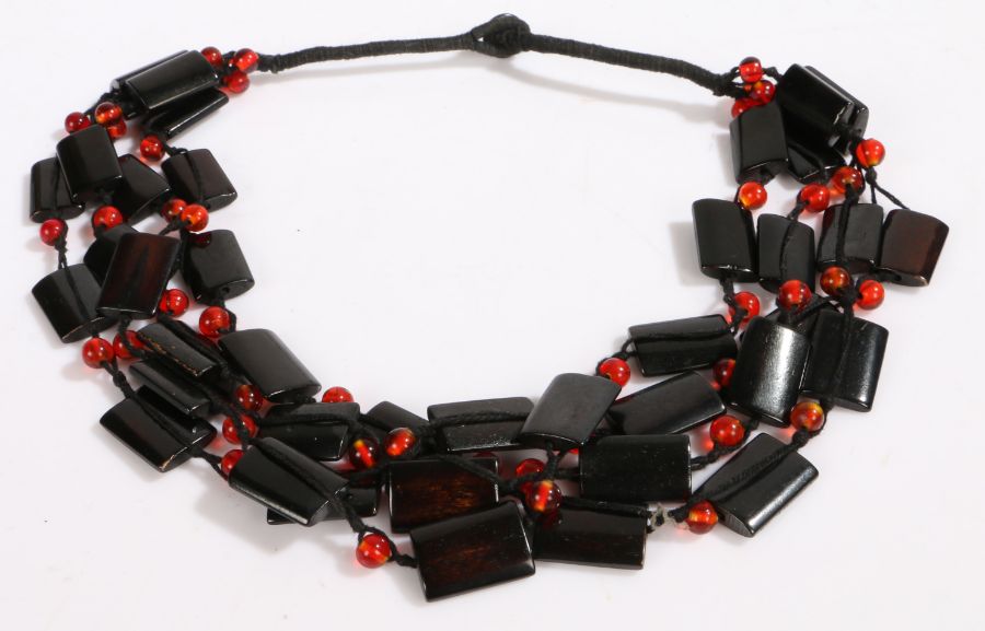 An art deco necklace with four rows of rectangular black beads intersected by spherical red beads,