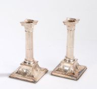 Pair of silver plated Corinthian column candlesticks, the bases with monogram, 20cm high