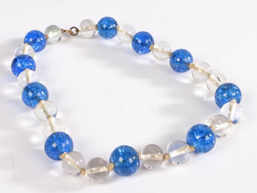 A crystal bead necklace with individually knotted blue and clear round crystal beads with a yellow
