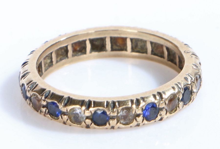 A 9 carat yellow gold ring set with blue and white cz. Ring size O 1/2. Weighing 3.3 grams.