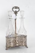 Silver plate on copper decanter stand, the pierced scroll cast handle above a trefoil form base