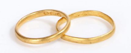 A pair of yellow gold rings with foreign markings. Assessed as 22 carat gold. Finger size M and K.