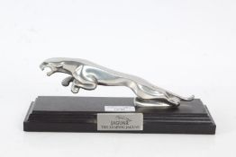 A Jaguar Metal desk ornament titled "The Leaping Jaguar" set on a wooden plinth, 22cm wide