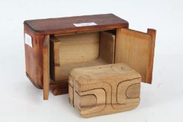 A wooden puzzle toy formed of intersecting pieces housed within a wooden box