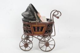 Four miniature bisque dolls, together with a miniature Victorian style pram