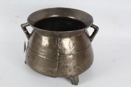 17th Century bronze cauldron, the flared rim above two angular handles and bulbous body, raised on