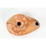 A terracotta oil lamp, in the Roman style with a scallop shell design, 10cm wide