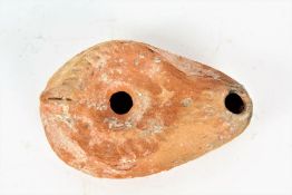 A terracotta oil lamp, in the Roman style with a scallop shell design, 10cm wide