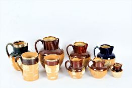 A Collection of nine Royal Doulton/ Doulton Lambeth stoneware jugs, three with silver rims some