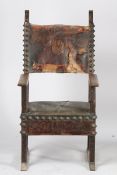 An Italian Baroque oak armchair, the leather pad back flanked by acanthus leaf tips above the