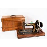 Frister Rossman manual sewing machine, the black body with foliate decoration, housed in a marquetry