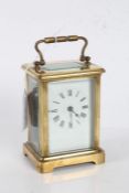 French brass cased carriage clock, the white enamel dial with black roman numerals, visible platform