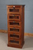 A Large 20th century haberdashery cabinet with a square top above six glazed drawers and a plinth