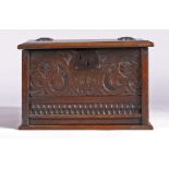 An oak box, made from 17th Century and later panels, the hinged top above a carved front panel, 50cm