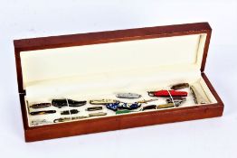 Collection of miniature penknives some in the form of shoes etc housed within a wooden display box -